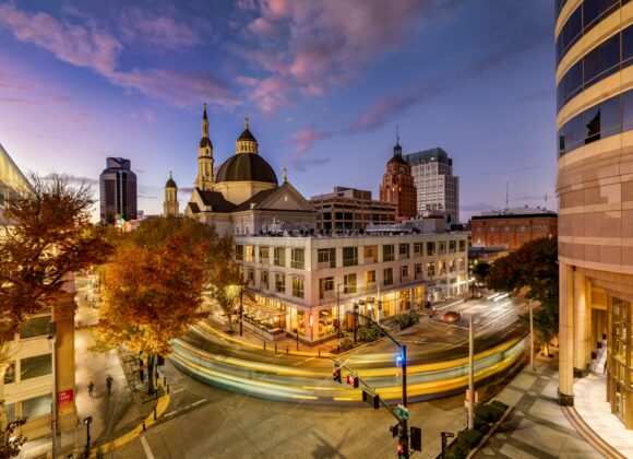 Best Argentina Travel Packing List A historic building with ornate architecture is illuminated at night, with city buildings in the background and a starry sky overhead. Cars and streetlights line the street below.