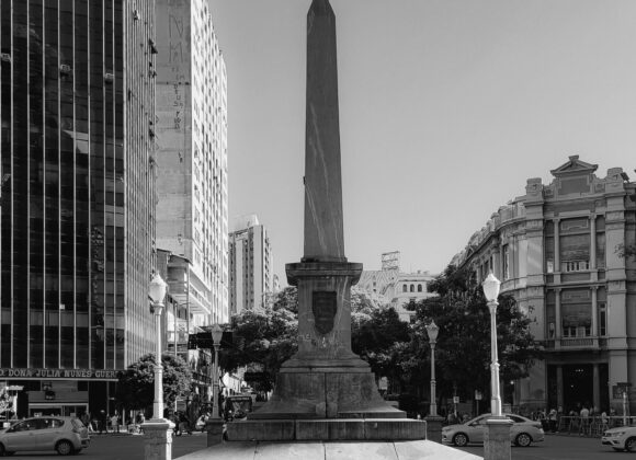 What to Wear in Buenos Aires in November 1. Black and white photo of a city monument surrounded by urban buildings and streets. 2. A black and white image depicting a monument centrally located in a bustling cityscape. 3. Black and white photograph showing a monument in the heart of a city, framed by surrounding architecture.