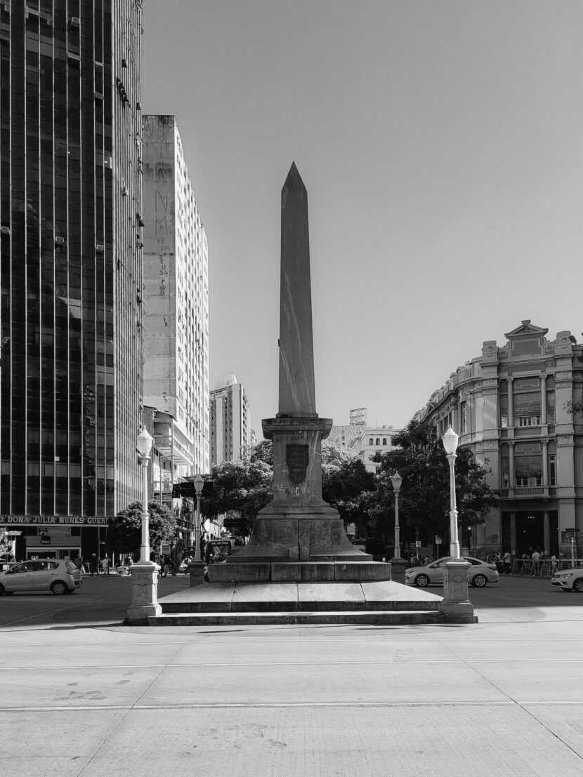 What to Wear in Buenos Aires in November 1. Black and white photo of a city monument surrounded by urban buildings and streets. 2. A black and white image depicting a monument centrally located in a bustling cityscape. 3. Black and white photograph showing a monument in the heart of a city, framed by surrounding architecture.