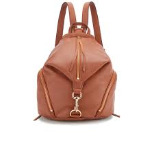 Rebecca Minkoff Julian Backpack Review A stylish brown leather backpack with a top handle, gold zippers, and a central clasp accent. The design is sleek and practical, conveying elegance.