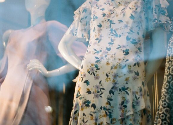 Leith Dresses and the Rise of the Leith Brand Mannequins in a shop window display floral and pastel dresses. The reflection on the glass adds a dreamy, elegant tone to the scene.