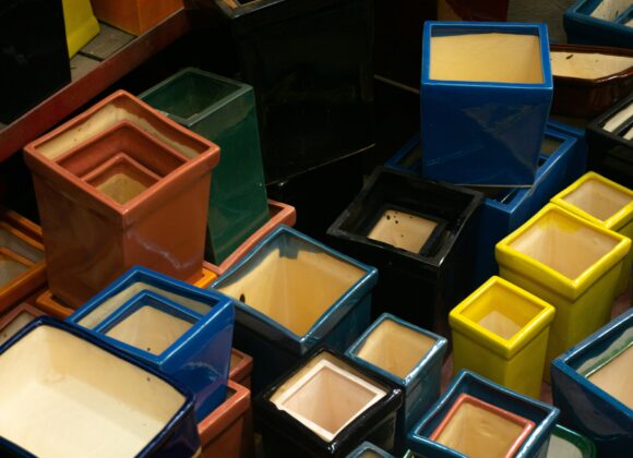 š§¼ Clean Dirty Packing Cube: Can You Wash Packing Cubes A collection of colorful, glossy, square-shaped ceramic pots stacked together. They vary in size and include hues such as red, blue, green, and yellow.