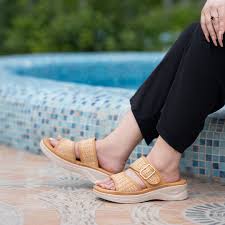Women’s Espadrilles Shoes A person wearing tan woven sandals with a buckle sits by a blue mosaic-tiled pool. They wear black pants, creating a relaxed and summery vibe.