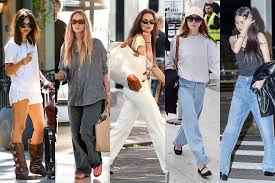 ✈️ Why I Love These Layering Clothes for Travel Five women in casual street styles walk in various settings. Outfits range from shorts and boots to flowing pants and sunglasses, exuding confident urban vibes.